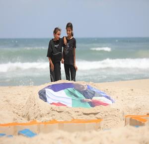 עזה – אמנים מציירים על חול חוף העיר עזה את דמותו של חוסאם חסן, מאמן נבחרת מצרים בכדורגל