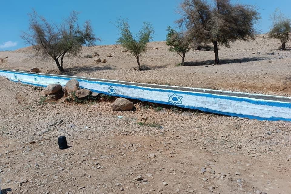 מתנחלים ישראלים ריססו דגל הכיבוש על מעיין מים ליד יריחו