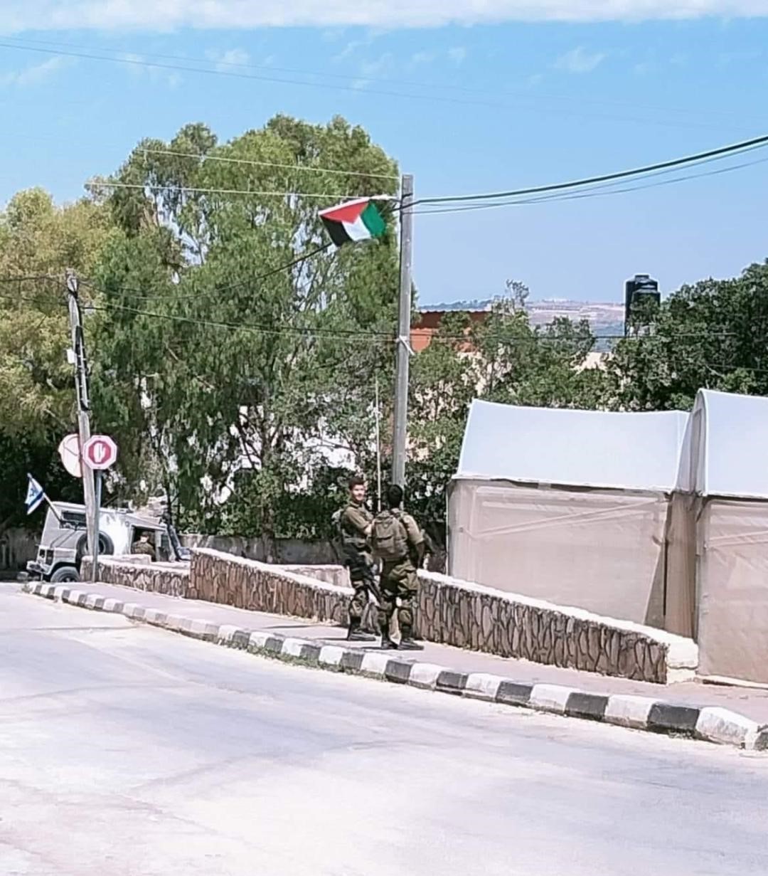 חיילי הכיבוש עסוקים בהורדת דגלי פלסטין